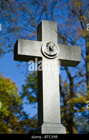 Graue Steinkreuz mit einem Relief von Jesus auf einem Friedhof in München, Deutschland Stockfoto