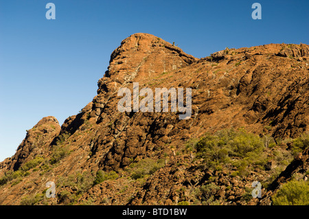 Große Wand von roten Felsen steigt bis zu eine scharfe Grat-Linie bilden Stockfoto