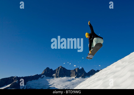 Snow Boarder macht einen Sprung auf Pisten im Bereich Juneau mit Mendenhall-Gletscher und Türme im Hintergrund, südöstlich, Alaska Stockfoto