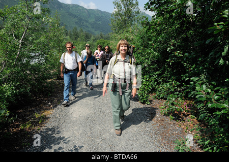 Weiblich-Forest Service Guide führt Wanderer auf einem Pfad nach Spencer Gletscher, Alaska Railroad Spencer Whistle Stop, Alaska Stockfoto