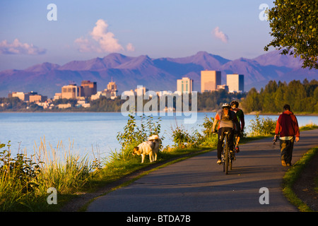 Menschen Sie, Joggen, Walken und Radfahren auf dem Coastal Trail mit Downtown Anchorage in der Ferne, Anchorage, Alaska Stockfoto