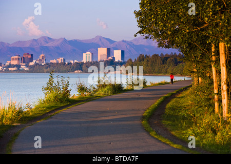 Menschen Sie, Joggen, Walken und Radfahren auf dem Coastal Trail mit Downtown Anchorage in der Ferne, Anchorage, Alaska Stockfoto