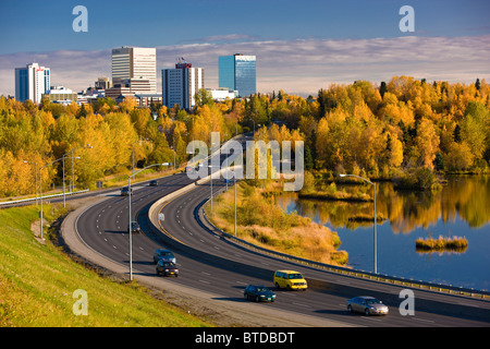 Malerische Aussicht von Minnesota Blvd. Verkehr entlang Westchester Lagune an einem sonnigen Tag mit der Innenstadt von Anchorage in der Ferne, Alaska Stockfoto