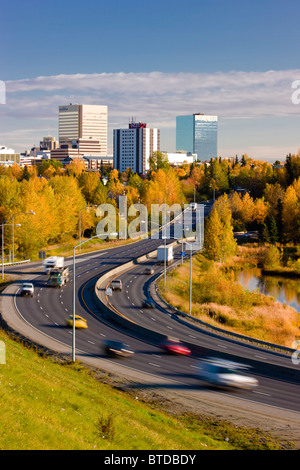 Malerische Aussicht von Minnesota Blvd. Verkehr entlang Westchester Lagune an einem sonnigen Tag mit der Innenstadt von Anchorage in der Ferne, Alaska Stockfoto
