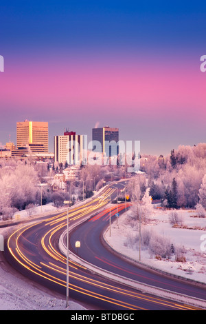 Blick auf den Sonnenuntergang des Verkehrs auf Minnesota Blvd. mit Downtown Anchorage im Hintergrund, Yunan Alaska Winter/n Stockfoto