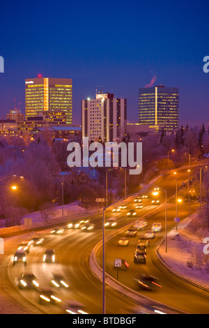 Twilight-Blick auf Verkehr auf Minnesota Blvd. mit Downtown Anchorage im Hintergrund, Yunan Alaska Winter/n Stockfoto
