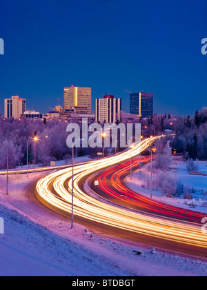 Twilight-Blick auf Verkehr auf Minnesota Blvd. mit Downtown Anchorage im Hintergrund, Yunan Alaska, Winter Stockfoto