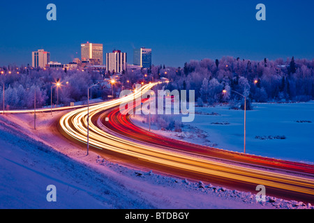 Twilight-Blick auf Verkehr auf Minnesota Blvd. mit Downtown Anchorage im Hintergrund, Yunan Alaska, Winter Stockfoto