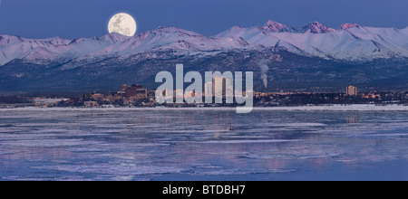 Panorama der Mondaufgang über die Skyline von Anchorage und Chugach Berge in der Dämmerung mit Feuerwerk, Alaska, COMPOSITE Stockfoto