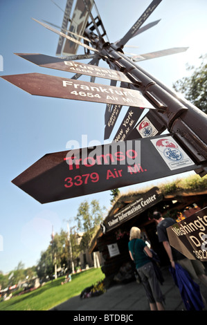 Kilometerstand Wegweiser außerhalb der Blockhütte und Downtown Visitor Information Center auf der Fourth Avenue in Anchorage, Alaska Stockfoto