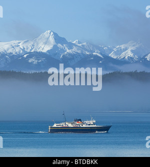 Durch den Nebel, Inside Passage mit verschneiten Gipfeln im Hintergrund, Alaska COMPOSITE Kreuzfahrten Alaska Marine Highway Ferry Stockfoto