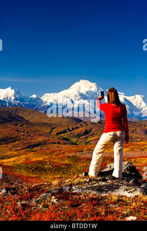 Eine Frau in Peters Hügeln wandern stoppt, um ein Bild von Mt. McKinley mit ihrem Handy, Denali Nationalpark, Alaska Stockfoto