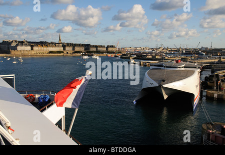 Französische nationale Flagge vom Heck eines Schiffes mit dem Hintergrund von St Malo, eine historische Stadt und Hafen im Westen Frankreichs Stockfoto