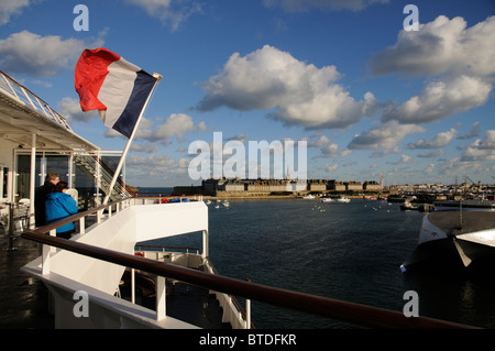 Französische nationale Flagge vom Heck eines Schiffes mit dem Hintergrund von St Malo, eine historische Stadt im Westen Frankreichs Stockfoto