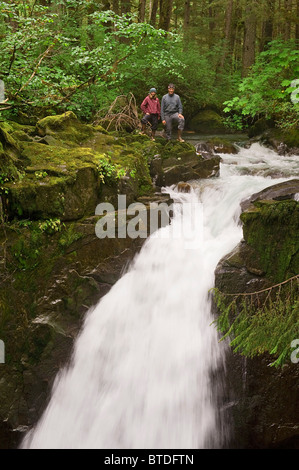 Zwei Wanderer stehen an der Spitze der Sägewerk Creek Falls im Tongass National Regenwald in der Nähe von Juneau, südöstlichen Alaska Stockfoto