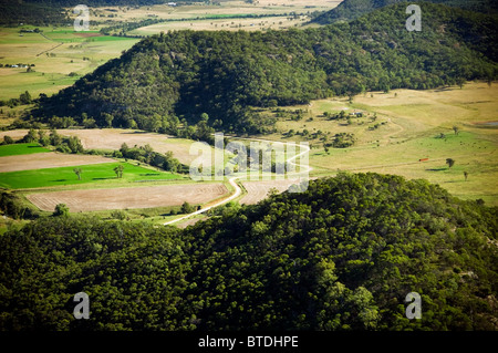 Eine Landstraße schlängelt sich durch Felder und Wiesen Stockfoto