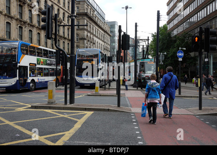Fußgänger überqueren einer verkehrsreichen Straße im Stadtzentrum von Manchester GROSSBRITANNIEN. foto DON TONGE Stockfoto