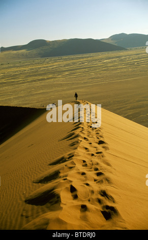 Linie von Touristen zu Fuß auf dem Kamm einer Düne Stockfoto