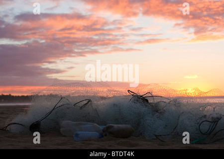 Fischernetze am Strand bei Sonnenuntergang Stockfoto