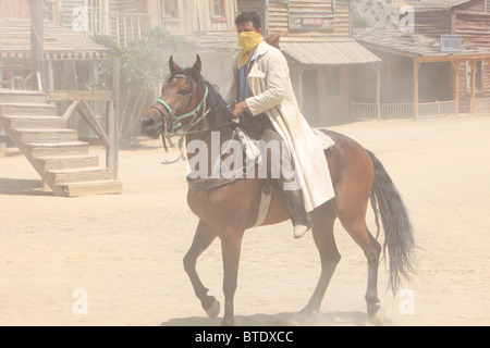 Ein Bankräuber, Reiten in die Stadt während einer Re-Inszenierung am Fort Bravo (ehemalige Spaghetti-Western-Film-Set) in Tabernas, Spanien Stockfoto