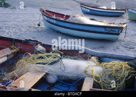 Angelboote/Fischerboote mit ihren feinen Netze liegen hochgezogen am Strand bei Ebbe Stockfoto