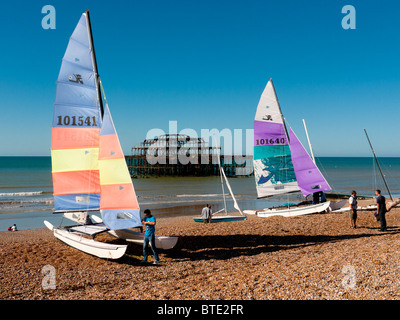 Yachten und Segeln Dingys am Strand von Brighton Pier West, East Sussex, Großbritannien Stockfoto