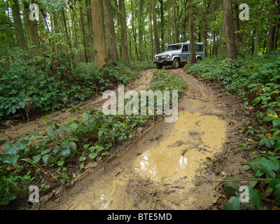 Silbernen Landrover Defender fahren auf einen extrem schlammigen Pfad in die Domaine d'Arthey Anwesen in Belgien Stockfoto