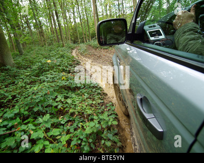 Range Rover Sport auf einem extrem matschig und rutschig Weg durch einen Wald fahren. Domaine d'Arthey, Belgien Stockfoto