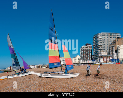 Yachten und Segeln Dingys am Strand von Brighton Pier West, East Sussex, Großbritannien Stockfoto