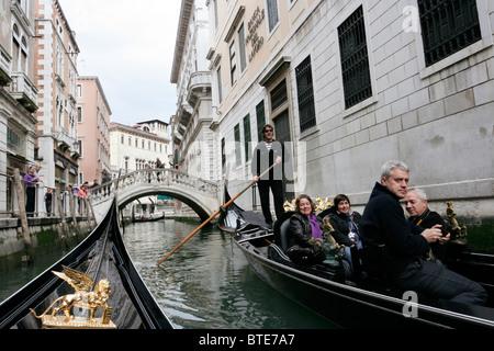 Touristen, die eine Fahrt mit einer Gondel in Venedig. Stockfoto