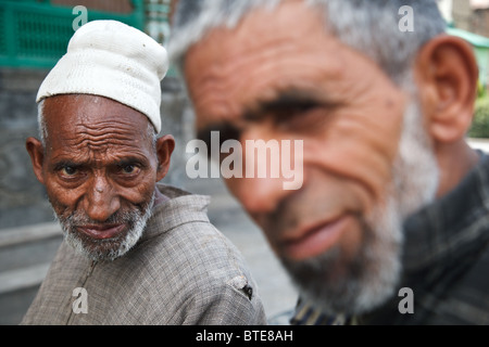 Ein Porträt der beiden alten muslimischen Männer sitzen vor einer Moschee in Srinagar, Jammu und Kaschmir, Indien Stockfoto