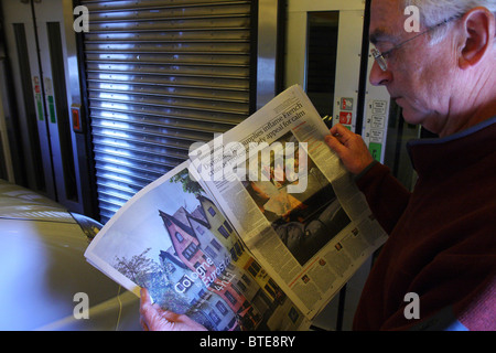 Aufnahme eines Mannes lesen die Zeitung the Guardian im Eurotunnel Zug. Innenseite Guardian Papier ist Werbung für Köln nach London-Route. Stockfoto