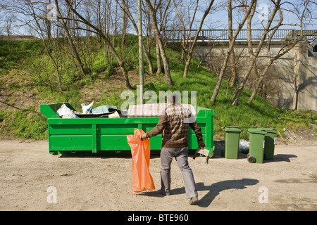 Mann unter Müll Müllcontainer Stockfoto