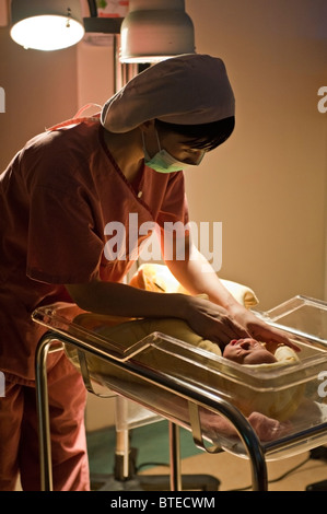 Krankenschwester, neugeborenes Baby mit Decke abdecken Stockfoto