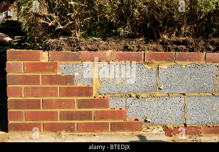 Neue Gartenmauer mit inneren Betonblöcke und äußeren roten Ziegeln. VEREINIGTES KÖNIGREICH. Stockfoto