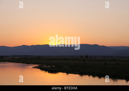 Sonnenuntergang hinter einer Bergkette am nördlichen Ufer des Sambesi in Sambia Stockfoto