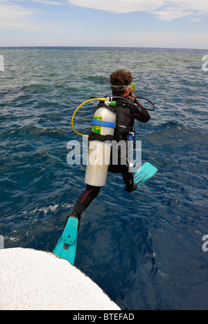 Taucher, die einen großen Schritt zu tun, ins Wasser geben Stockfoto