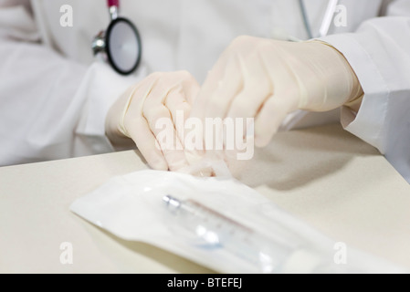 Mitarbeiter öffnen sterile Verpackung, enthält medizinische Versorgung Stockfoto