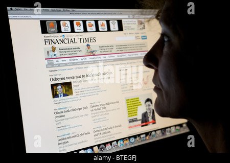 Frau liest Financial Times website Stockfoto