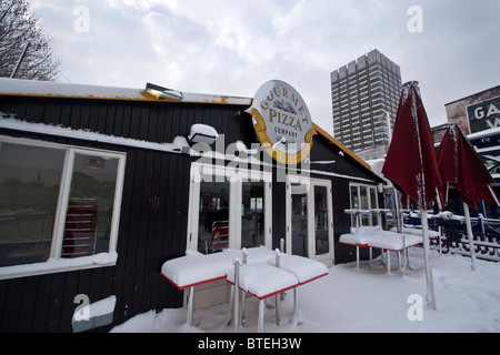 Gourmet-Pizza-Restaurant mit ITV, die Gebäude im Hintergrund, London Gabriels Wharf im Schnee Stockfoto