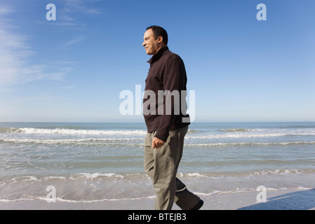Reifer Mann zu Fuß am Strand Stockfoto