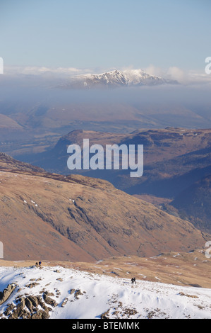 Wanderer am grünen Giebel mit Schnee bedeckt Blencathra in der Ferne. Englischen Lake District Bergblick. Stockfoto