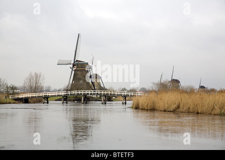 Windmühlen und Brücke der Unesco World Heritage Site Kinderdijk mit schmelzen Eis vor, Süd-Holland, Niederlande Stockfoto