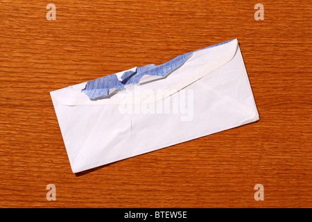 Eine gebrauchte mailing Postumschlag aufgerissen. Braune Holz gemaserte Hintergrund Stockfoto