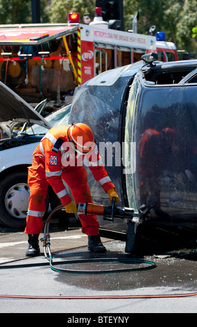 Notfall Rettungskräfte schneiden Sie eine Person aus einem abgestürzten Fahrzeug. Stockfoto