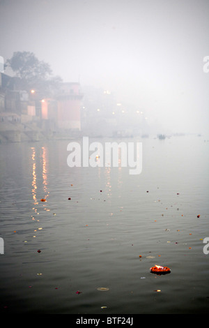 Der Fluss Ganges am frühen Morgen mit schwimmenden angeboten, Dasaswamedh Ghat, Varanasi, Uttar Pradesh, Indien. Stockfoto