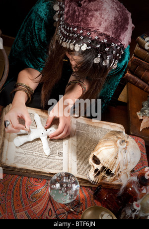 Voodoo-Zigeuner setzen Nadeln in eine Puppe, die einen Zauberspruch Stockfoto