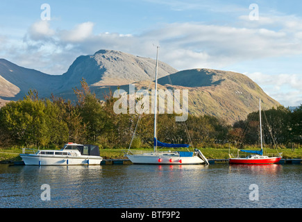 Yachten & ein Motorboot vor Anker auf dem kaledonischen Kanal in Banavie in der Nähe von Fort William & Ben Nevis hinter Stockfoto