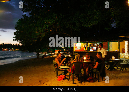 Leute sitzen in einer Bar am Strand von Unawatuna nahe Galle, Sri Lanka. Stockfoto