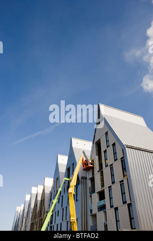 Bauarbeiter in Hubarbeitsbühnen Eimer arbeiten am Gebäude außen Stockfoto